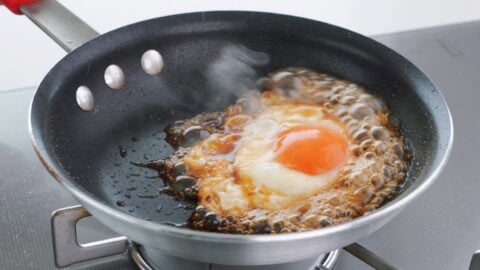 Glazing fried egg with teriyaki sauce.