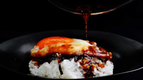 Serving fried teriyaki egg with rice and extra sauce.