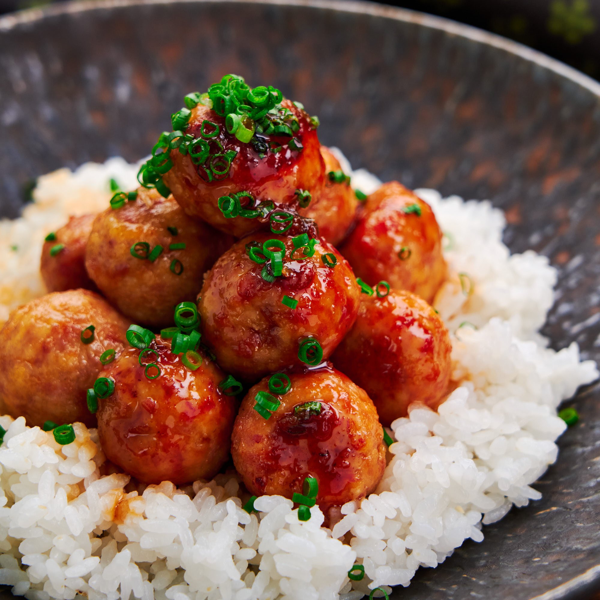 Juicy chicken teriyaki meatballs on a bed of cooked rice makes for an easy weeknight meal.