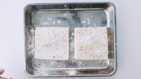 Drained tofu seasoned with black pepper and dusted with potato starch.