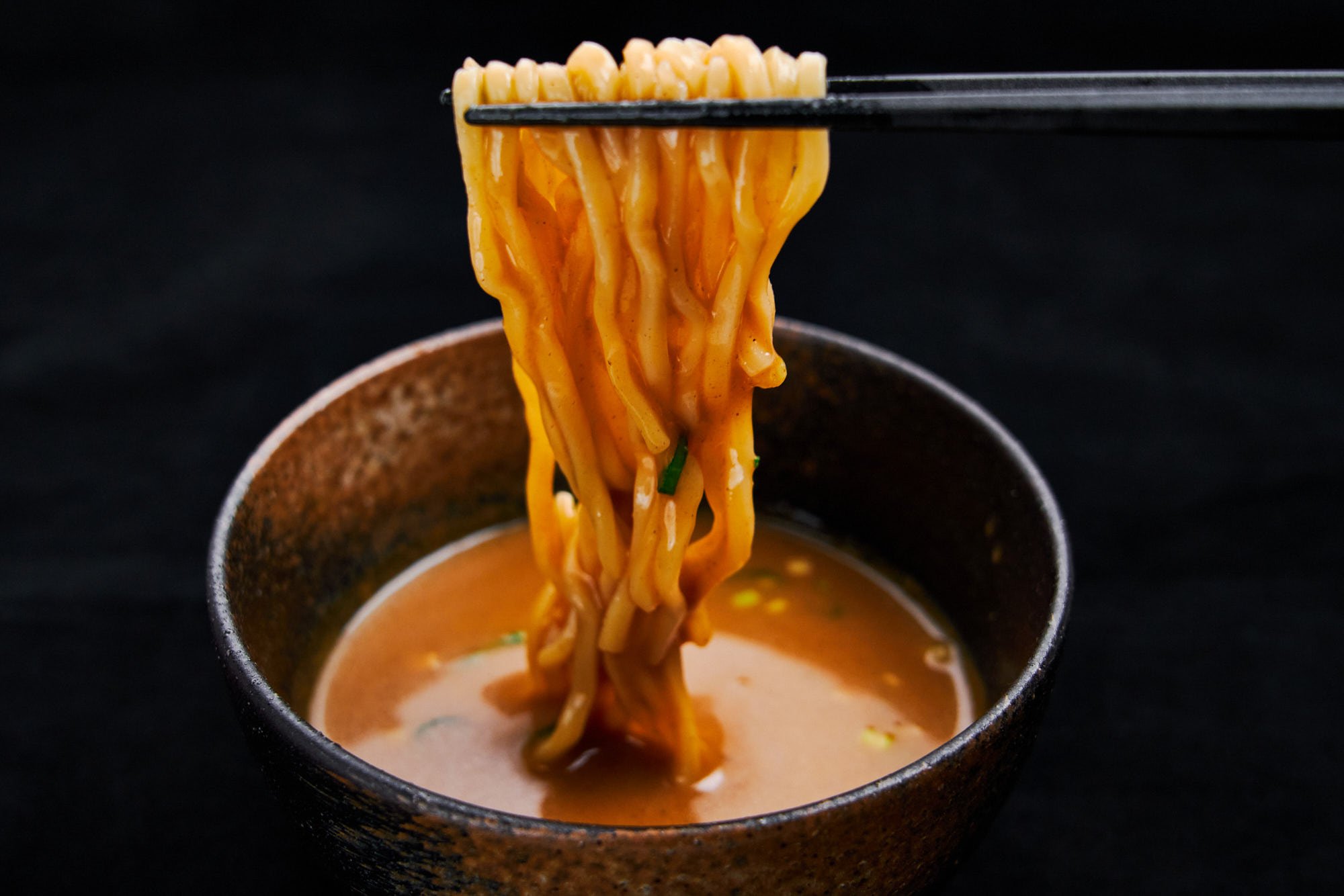 Dipping thick ramen noodles in a rich tsukemen dipping sauce.