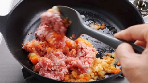 Crumbling ground pork and grated aromatics.