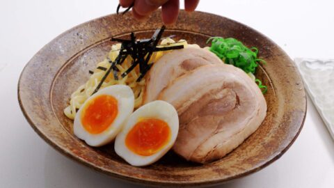 Ramen noodles topped with nori, scallions, chashu, and egg.