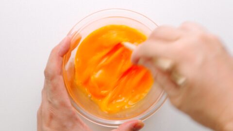 Beating eggs with chopsticks for making thin omelettes.