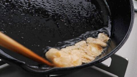 Frying garlic slices in wagyu fat to make crispy chips.
