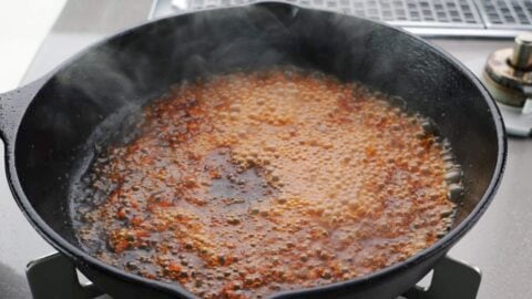 Japanese steak sauce bubbling in a cast iron skillet.
