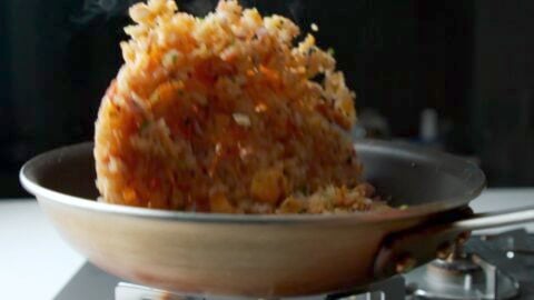 Tossing fried rice in a frying pan.