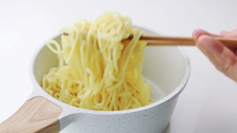 Tossing yakisoba noodles with oil.