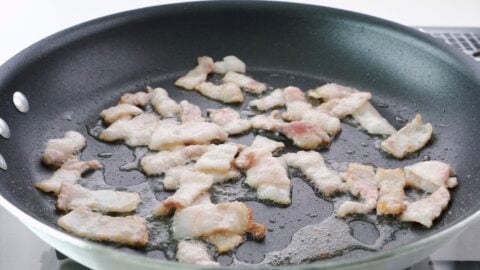 Frying thinly sliced pork belly.
