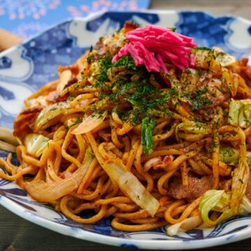 A plate of homemade Japanese yakisoba (stir-fried ramen noodles) with pork cabbage, onions and benishoga (red pickled ginger).