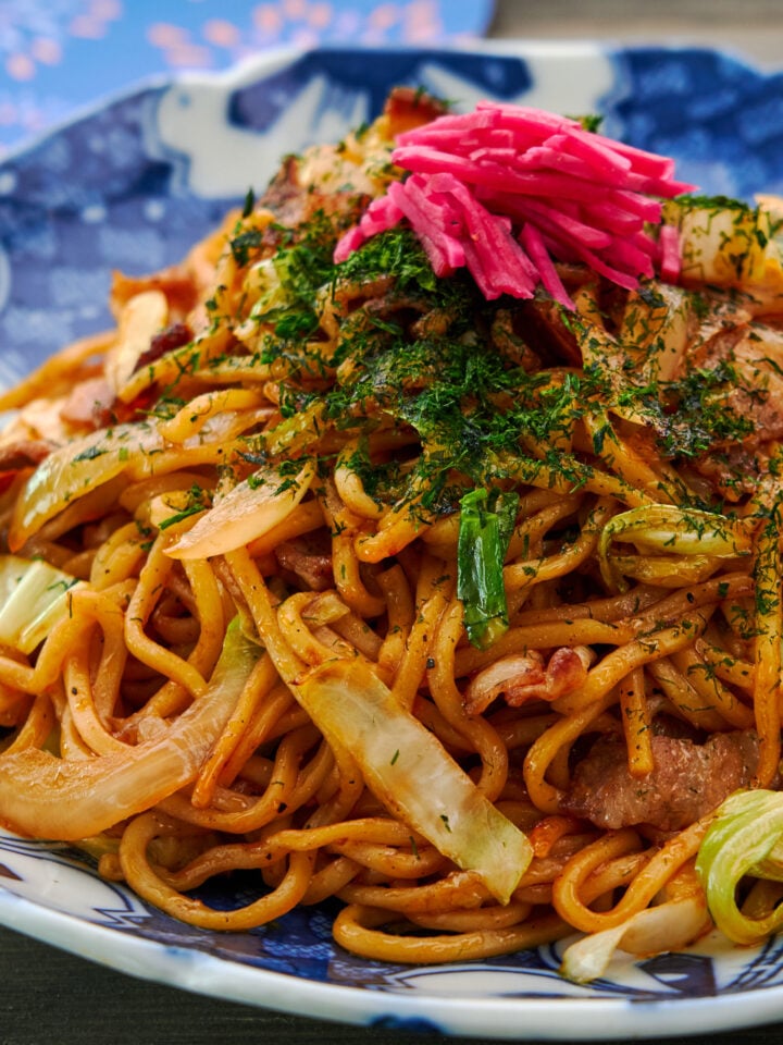A plate of homemade Japanese yakisoba (stir-fried ramen noodles) with pork cabbage, onions and benishoga (red pickled ginger).