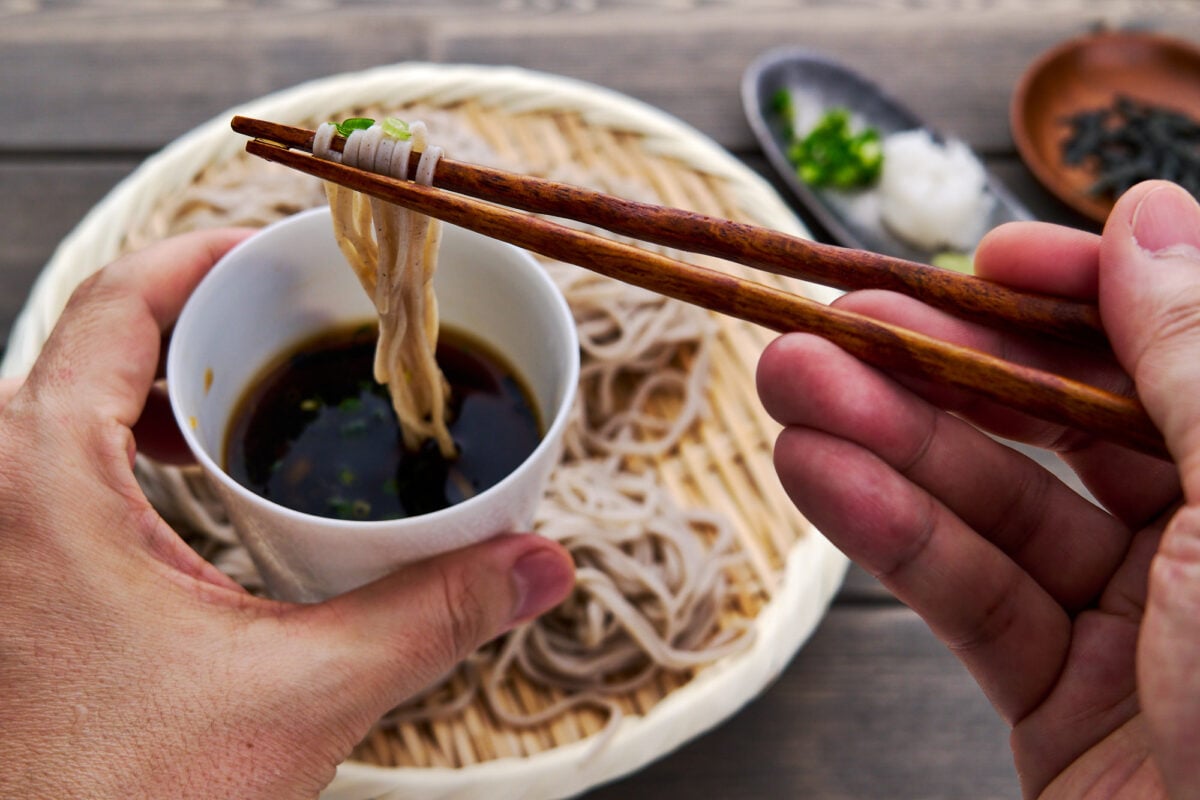 Cold soba noodles get dipped in an umami-packed dashi stock loaded with condiments.